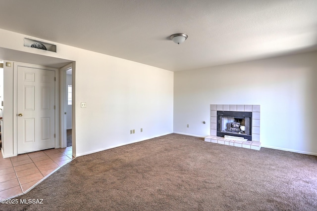 3381 W Calle De La Bajada, Tucson, AZ 85746 - unfurnished living room featuring carpet, baseboards, a tiled fireplace, and tile patterned flooring