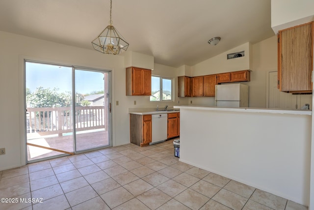 3381 W Calle De La Bajada, Tucson, AZ 85746 - kitchen featuring white appliances, light countertops, brown cabinets, vaulted ceiling, and a sink