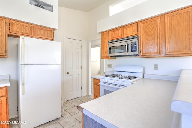 3381 W Calle De La Bajada, Tucson, AZ 85746 - kitchen with white appliances, light countertops, and light tile patterned floors