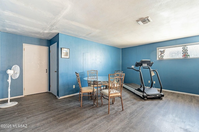 dining area featuring wood finished floors, visible vents, and baseboards