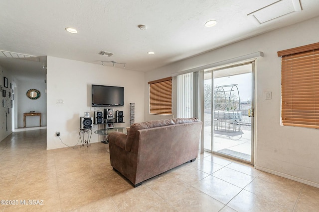 living room featuring recessed lighting, visible vents, a textured ceiling, and baseboards