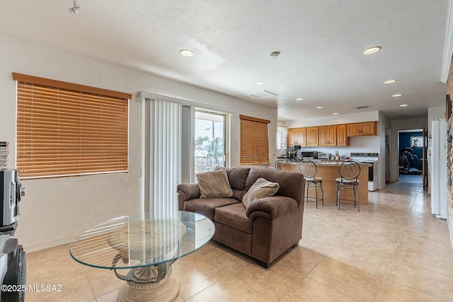 living room featuring a textured ceiling, baseboards, and recessed lighting