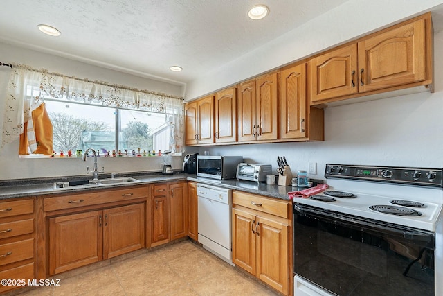 kitchen featuring white dishwasher, a sink, electric stove, brown cabinetry, and stainless steel microwave