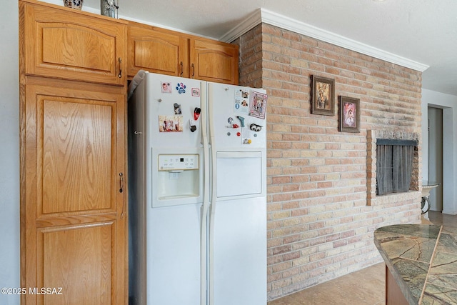 kitchen featuring white fridge with ice dispenser, brown cabinets, ornamental molding, and brick wall