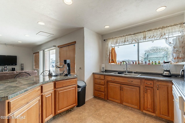 kitchen with tile countertops, brown cabinets, a sink, and open floor plan