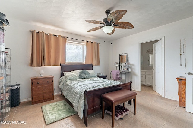 bedroom featuring light tile patterned floors, ensuite bathroom, a ceiling fan, and baseboards