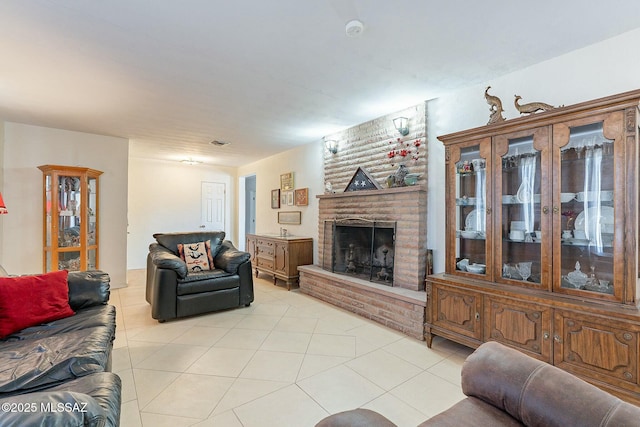 living room with a brick fireplace and light tile patterned floors