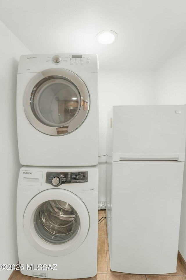 washroom featuring stacked washing maching and dryer and light tile patterned floors