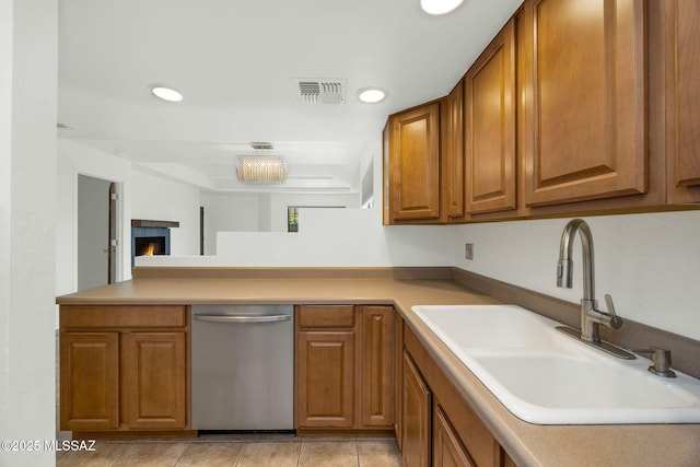 kitchen with brown cabinetry, recessed lighting, visible vents, and a sink