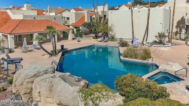 pool featuring a residential view, fence, a community hot tub, and a patio