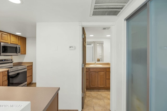 kitchen featuring visible vents, light tile patterned flooring, stainless steel appliances, a sink, and recessed lighting