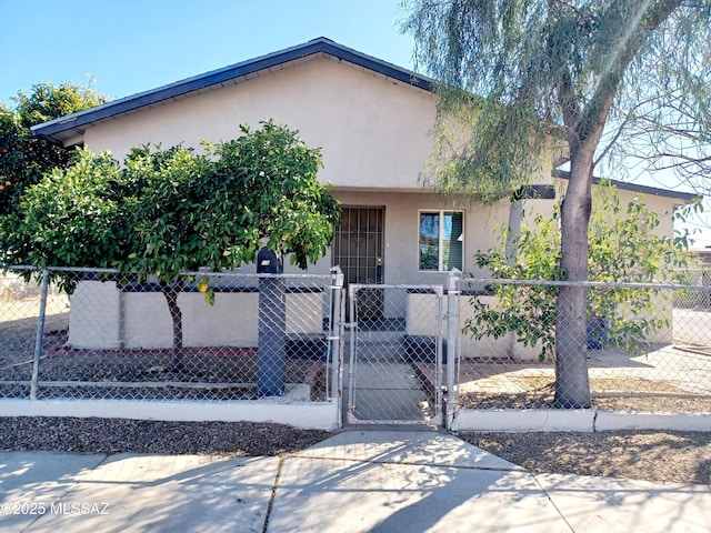 view of front of home with a fenced front yard and stucco siding