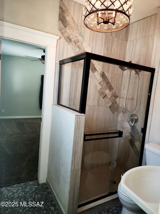 full bath featuring an inviting chandelier, a shower stall, and a sink