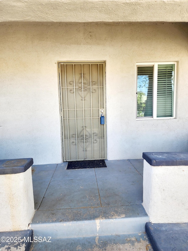 view of exterior entry with stucco siding