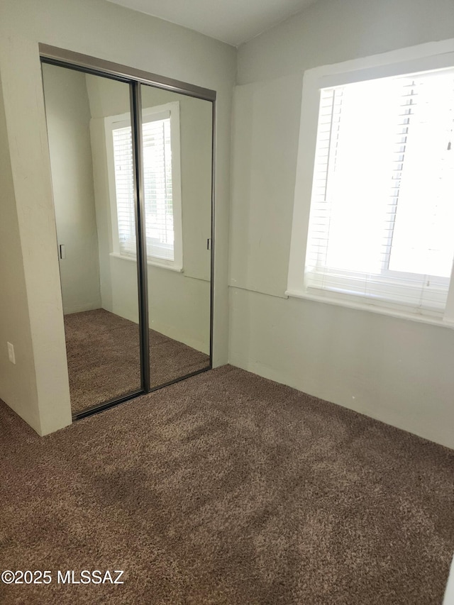 unfurnished bedroom featuring a closet and carpet