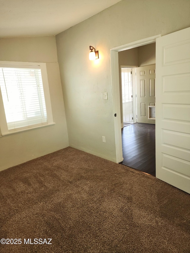 spare room with dark colored carpet