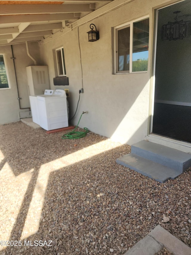 exterior space featuring washer / dryer and stucco siding