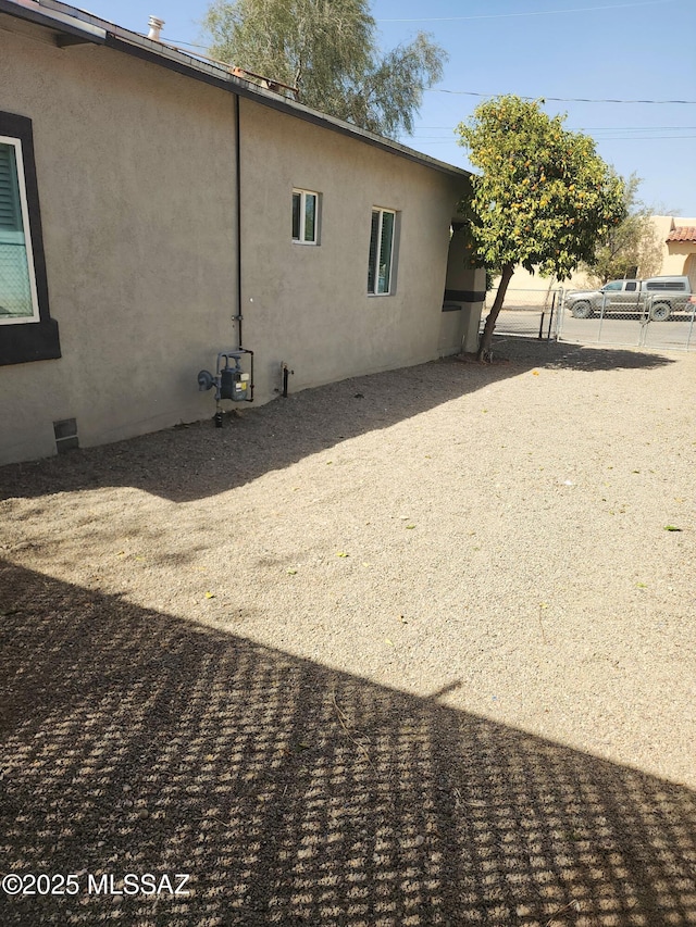 view of side of home featuring crawl space and stucco siding