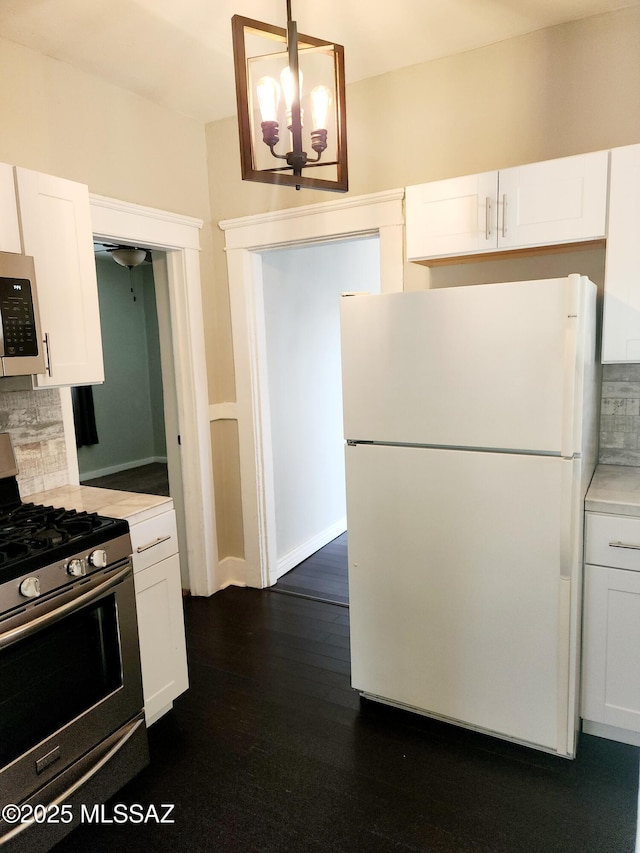 kitchen featuring appliances with stainless steel finishes, light countertops, backsplash, and white cabinetry