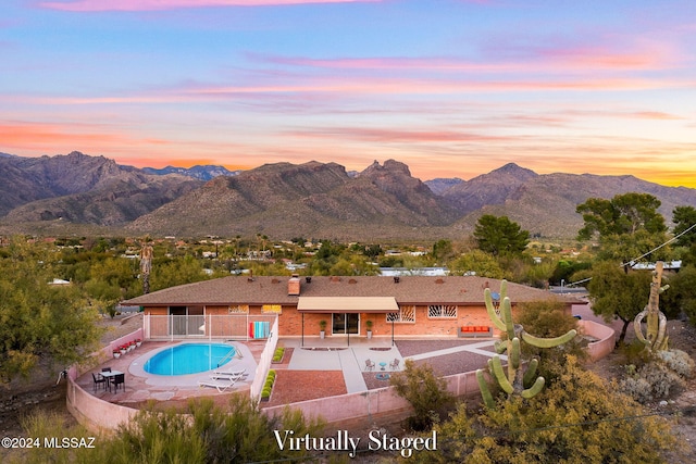 view of pool with a fenced in pool, a patio area, fence, and a mountain view