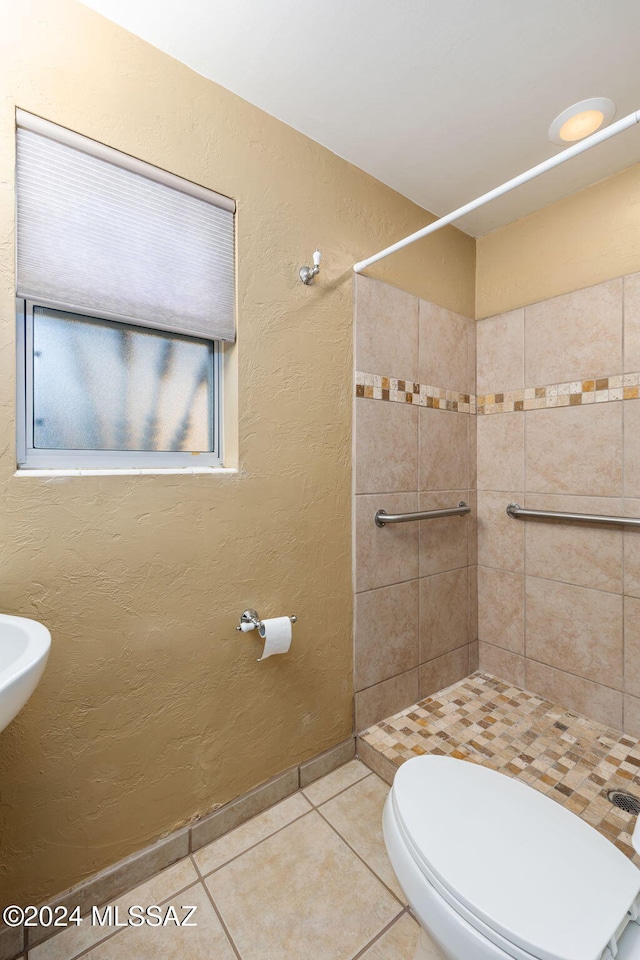 full bathroom with toilet, tile patterned flooring, a tile shower, and a textured wall