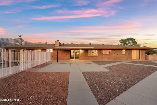 ranch-style home with brick siding, a patio, and fence