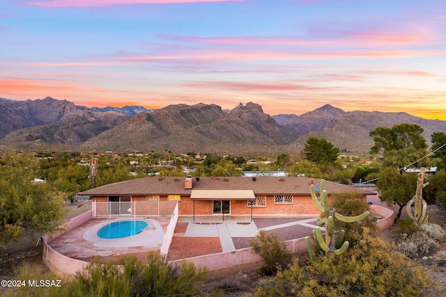 view of swimming pool with a fenced in pool, a patio, a mountain view, a fenced backyard, and a jacuzzi