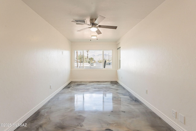 spare room with ceiling fan, finished concrete floors, and baseboards