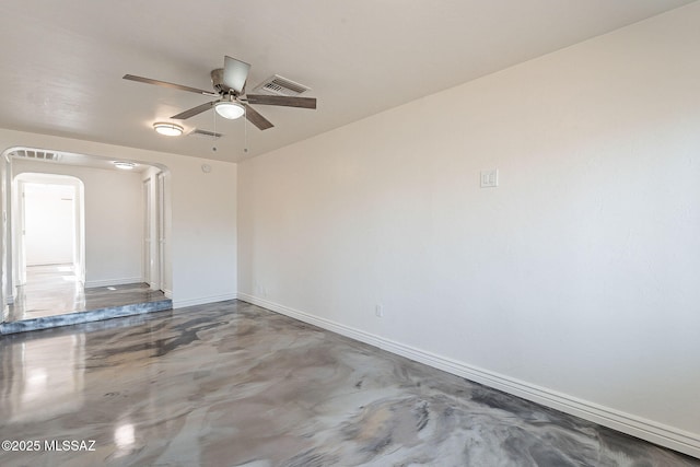 empty room with finished concrete flooring, visible vents, baseboards, and ceiling fan