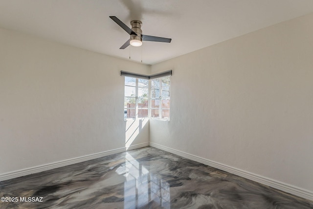 empty room featuring a ceiling fan and baseboards