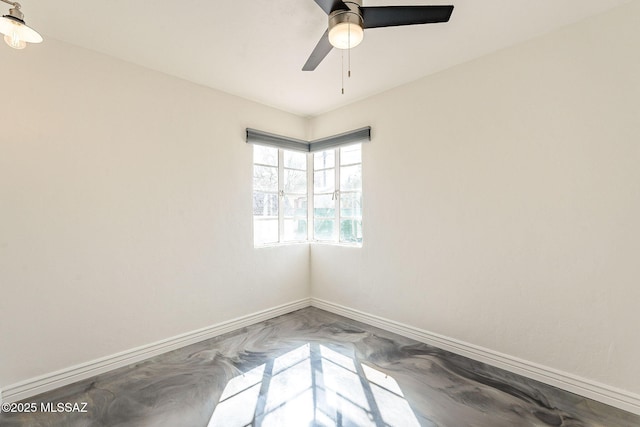 empty room featuring ceiling fan and baseboards