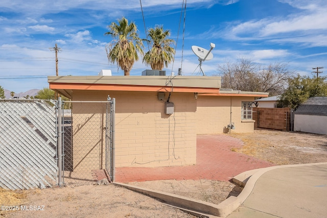 view of side of home featuring a gate and fence