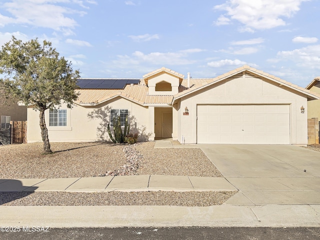 view of front of property with a garage, concrete driveway, a tile roof, and stucco siding