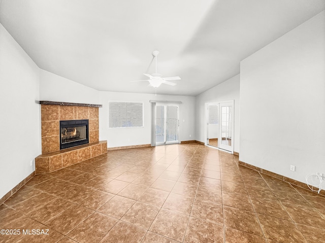 unfurnished living room featuring lofted ceiling, tile patterned flooring, ceiling fan, and a tile fireplace