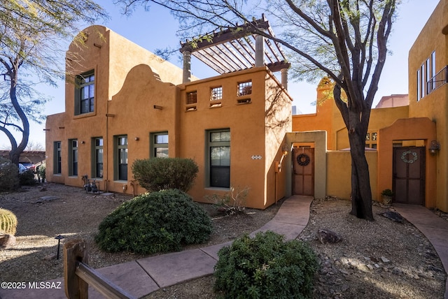 view of front of home with a gate, fence, and stucco siding