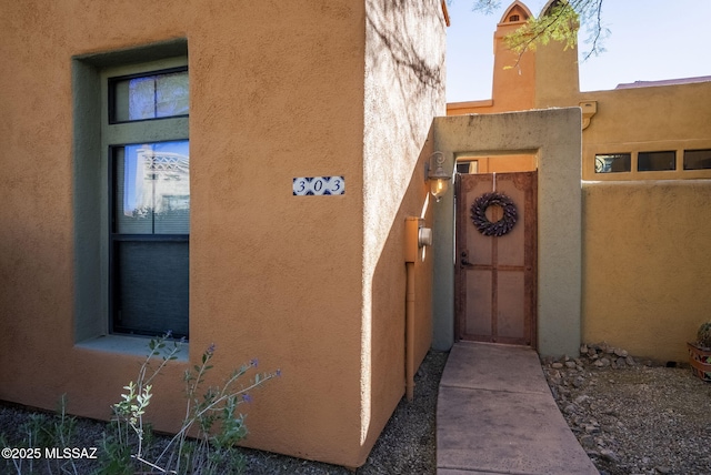 view of home's exterior with a gate and stucco siding