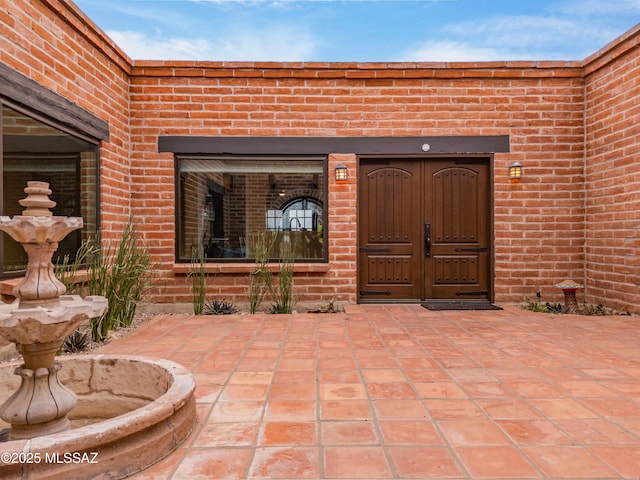 view of exterior entry with brick siding