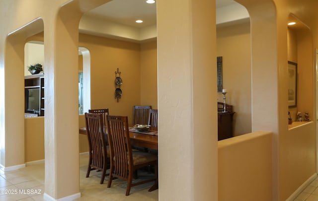 dining room featuring recessed lighting, arched walkways, baseboards, and tile patterned floors