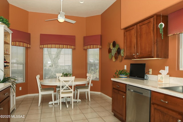 kitchen with a ceiling fan, light countertops, stainless steel dishwasher, and light tile patterned floors