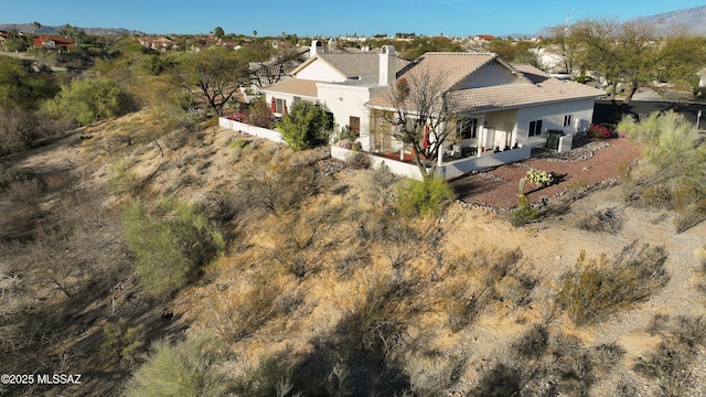 rear view of property featuring central air condition unit, a patio area, stucco siding, and a tiled roof