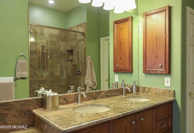 bathroom featuring double vanity, a sink, and a shower stall