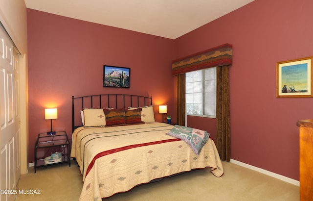 carpeted bedroom with a closet and baseboards