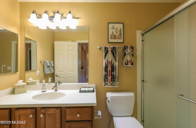 full bathroom with vanity, a shower stall, and toilet