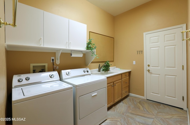 clothes washing area featuring cabinet space, baseboards, a sink, and independent washer and dryer