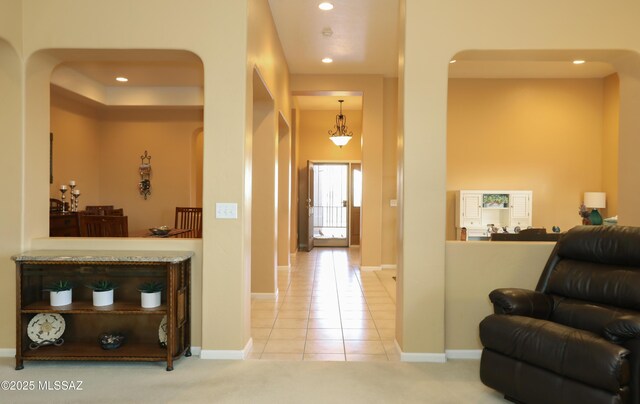 hall with baseboards, carpet flooring, tile patterned flooring, and recessed lighting