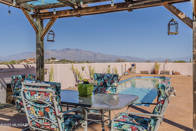 view of patio / terrace featuring a fenced backyard, a mountain view, a pergola, and a fenced in pool