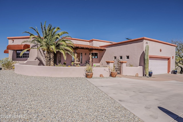 view of front of house with a garage, driveway, and stucco siding