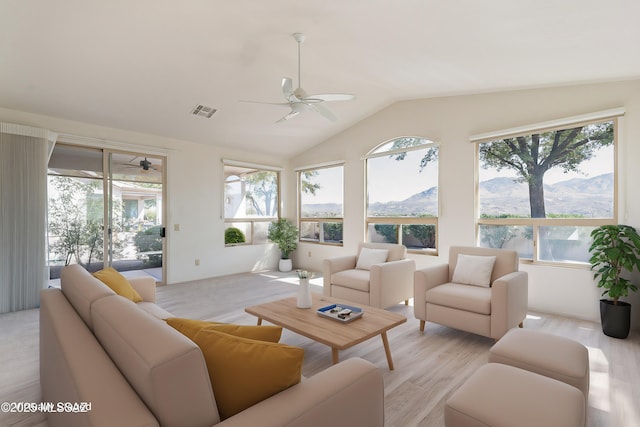 living area featuring a mountain view, lofted ceiling, visible vents, and a ceiling fan