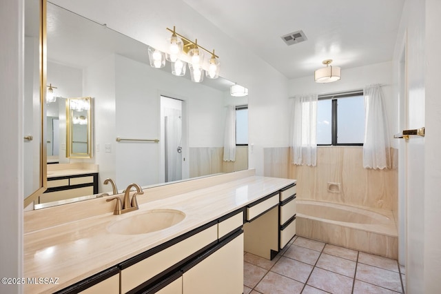 bathroom with a tub to relax in, tile patterned flooring, visible vents, and vanity