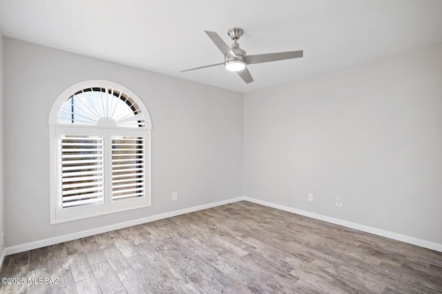 unfurnished room featuring baseboards, a ceiling fan, and wood finished floors